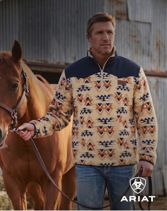 Person standing beside a horse wearing western-inspired apparel.