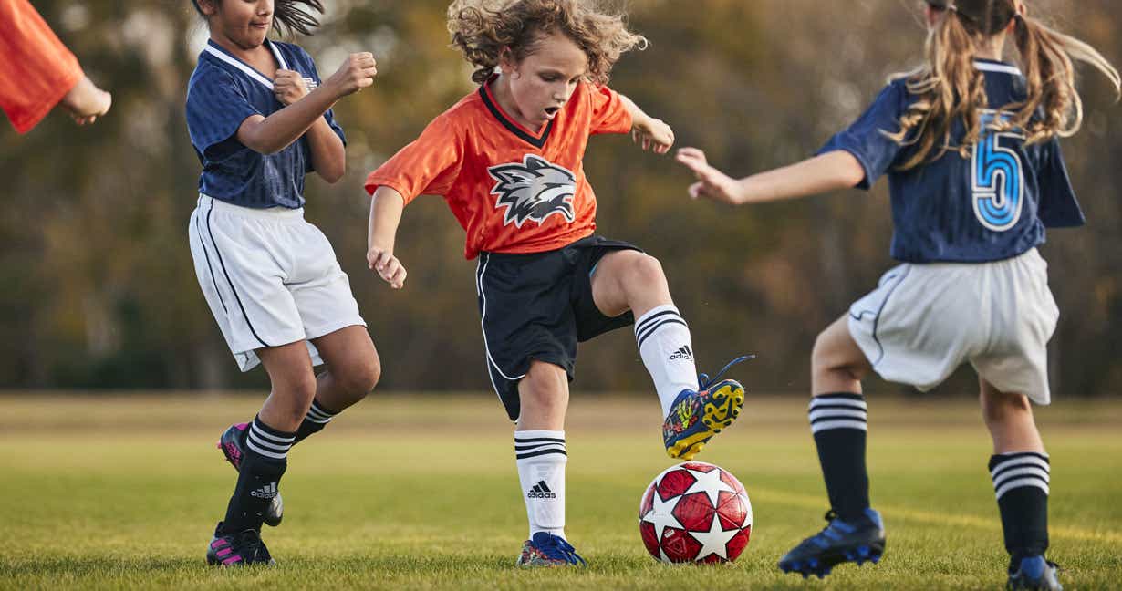Kids playing a soccer match on a field