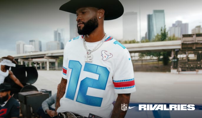 Person wearing a football jersey outdoors with Rivalries logo and city skyline in the background.