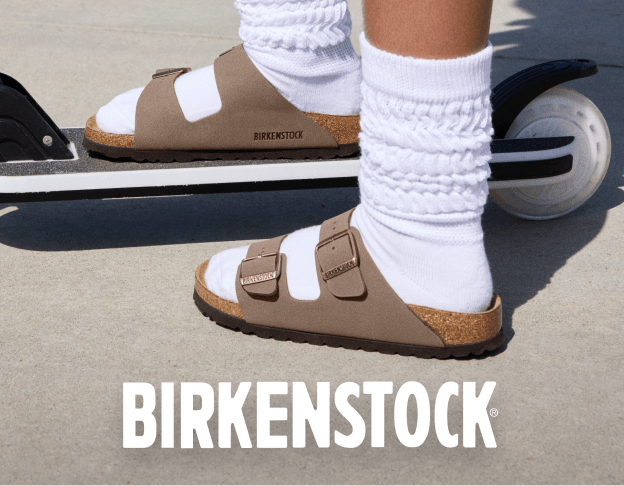 Close-up of Birkenstock sandals paired with white socks on a scooter. Birkenstock