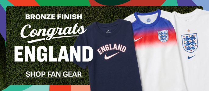 Promotional banner featuring England fan apparel, including a navy England Nike T-shirt and two England soccer jerseys. White text on a grass-textured background reads, “Bronze Finish Congrats England” and “Shop Fan Gear,” with colorful geometric accents framing the banner.