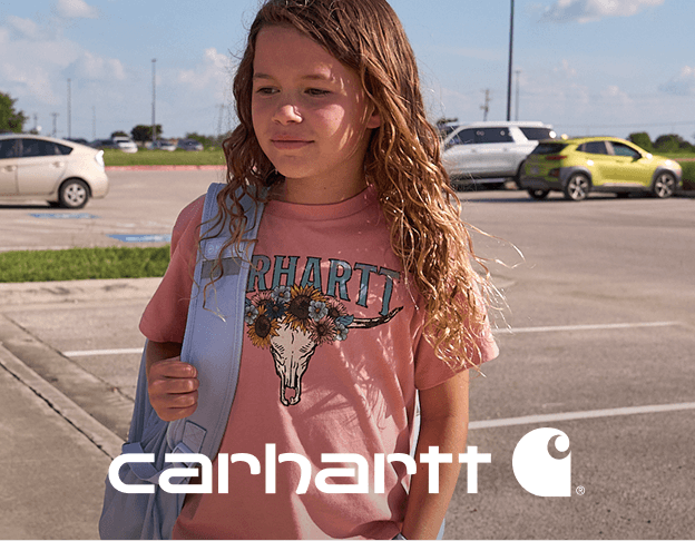 Person wearing a Carhartt graphic T-shirt standing in a parking lot. Carhartt