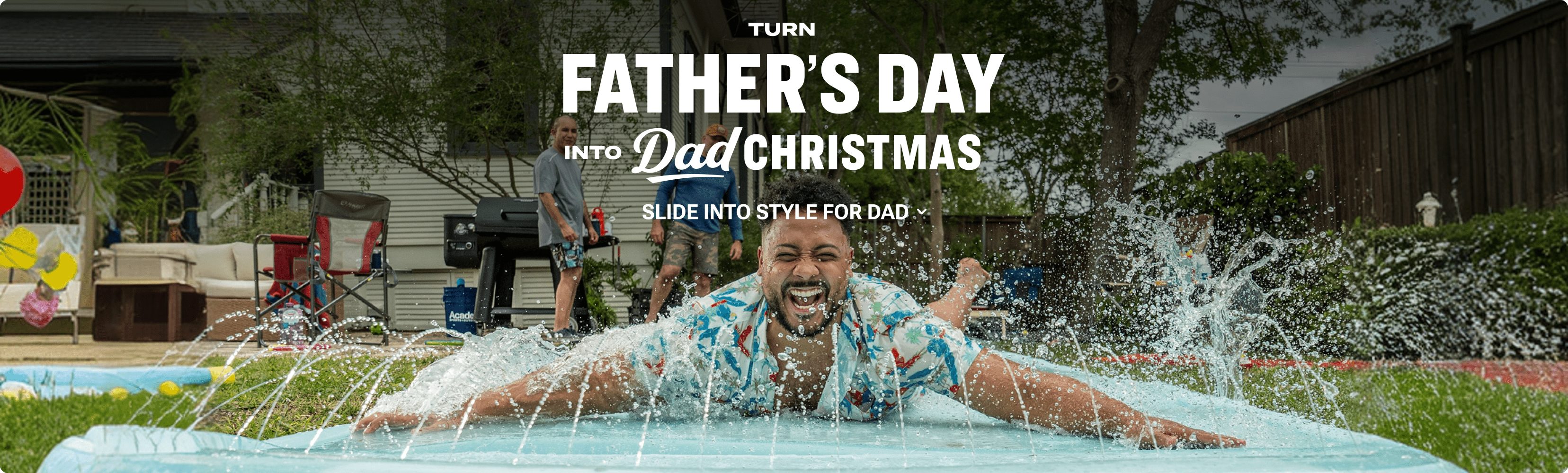 Father’s Day promotional banner showing a person sliding across a backyard inflatable water slide while others stand near a grill in the background. Overlaid text reads ‘Turn Father’s Day into Dad Christmas’ and ‘Slide into style for dad'