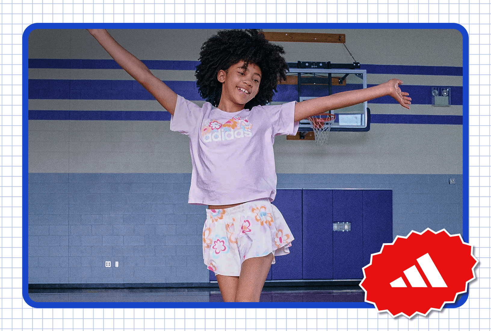 Person wearing an adidas T-shirt and patterned shorts standing in a gymnasium basketball court.