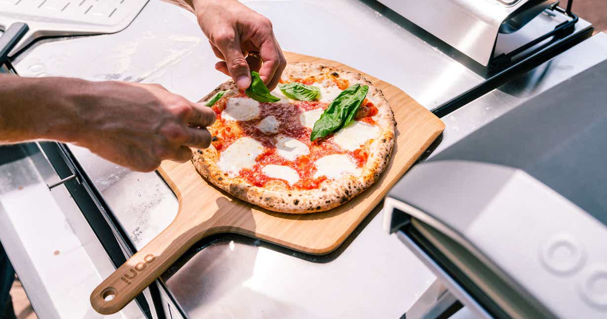 Topping off a freshly baked pizza