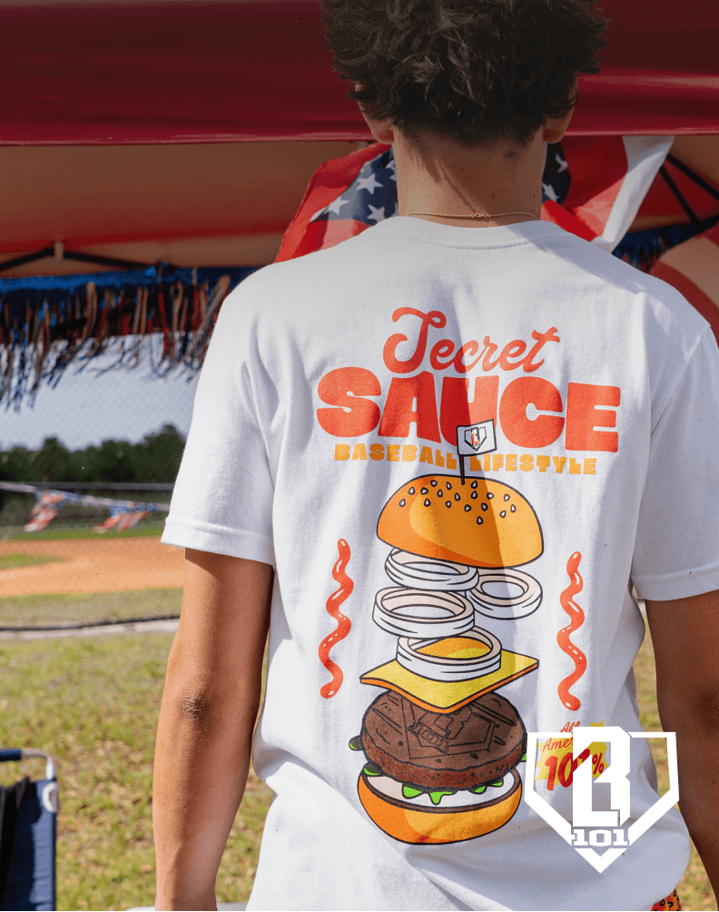 Person wearing a white graphic t-shirt with a burger design, with Baseball Lifestyle 101 branding.