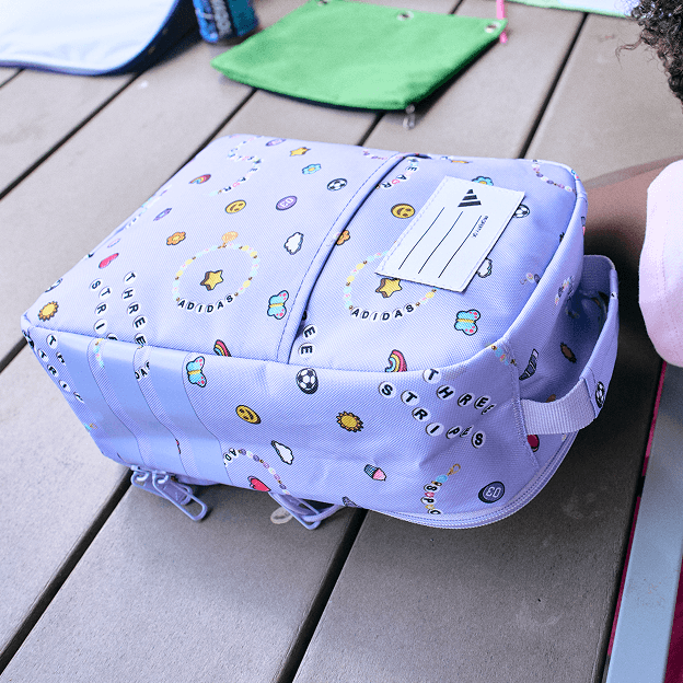 Blue patterned lunch box with top handle on outdoor table.
