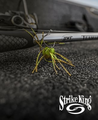 Close-up of a green Strike King fishing lure attached to a fishing rod, with Strike King logo in the corner.