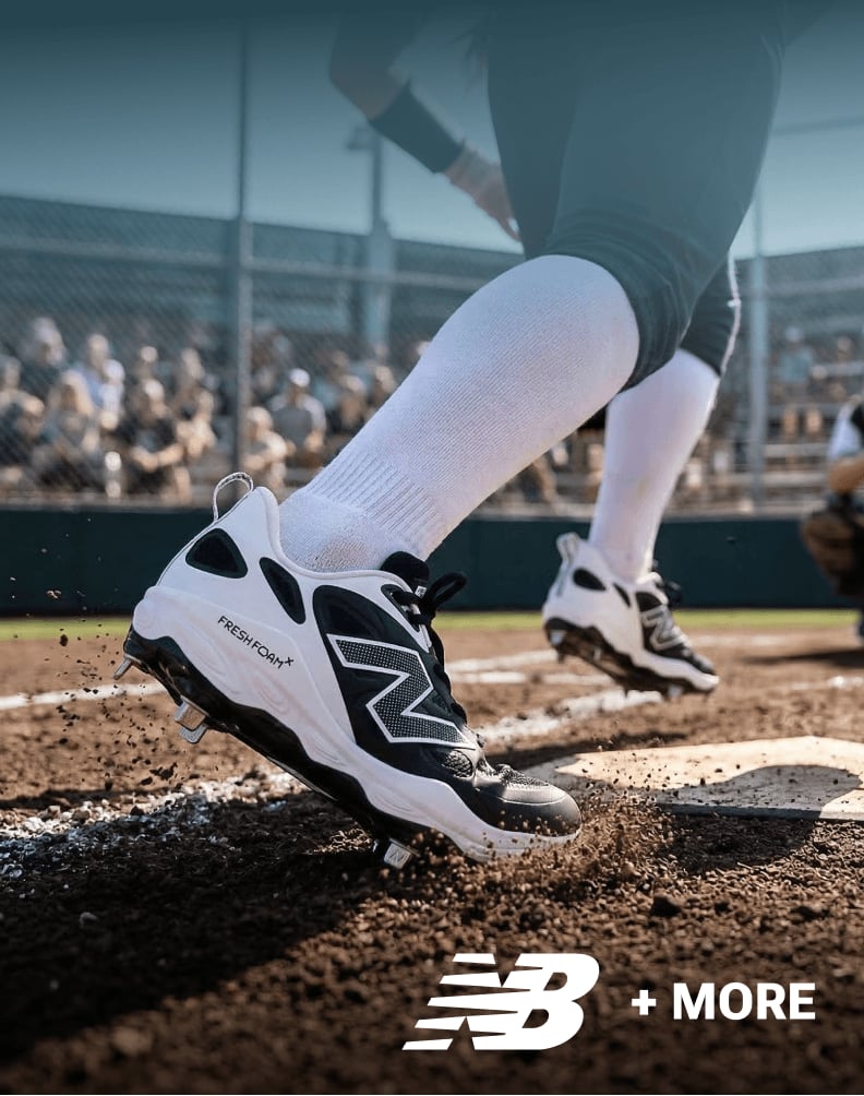 Close-up of a baseball player wearing New Balance cleats digging into dirt on the field.