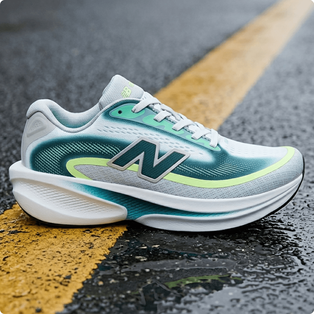 White and teal New Balance Ellipse V1 running shoe with neon accents on a wet asphalt road with a yellow center line.