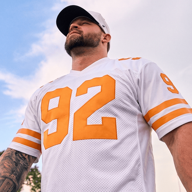 Person wearing a white Tennessee Volunteers football jersey with bold orange numbers.