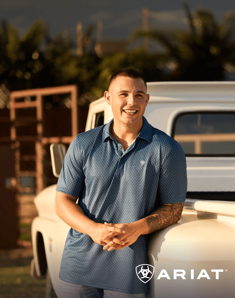 Person wearing a short-sleeve polo shirt standing outdoors near a vehicle.