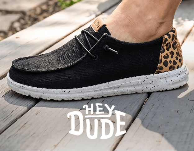 Black HEYDUDE slip-on shoes with leopard print detail.