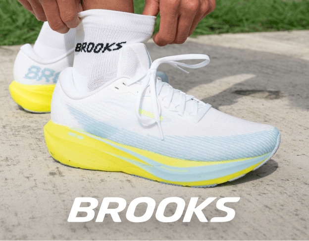 White Brooks running shoes with yellow sole on pavement.