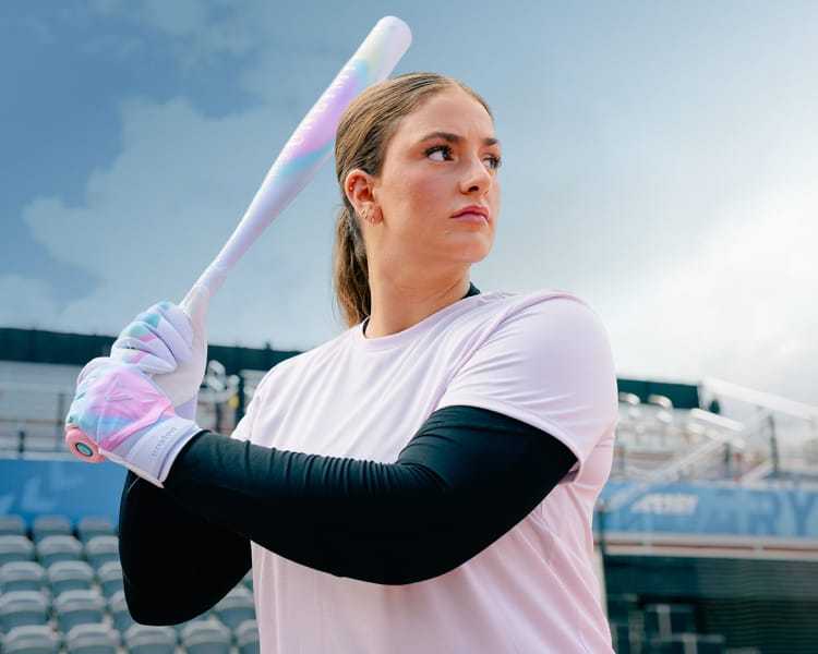Softball player holding an Easton fastpitch bat in a stadium setting. Easton logo appears in the lower-right corner.