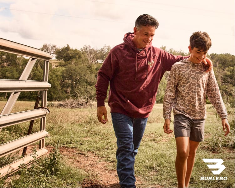 Two people walking outdoors beside wooden steps, wearing layered fall clothing from Burlebo,