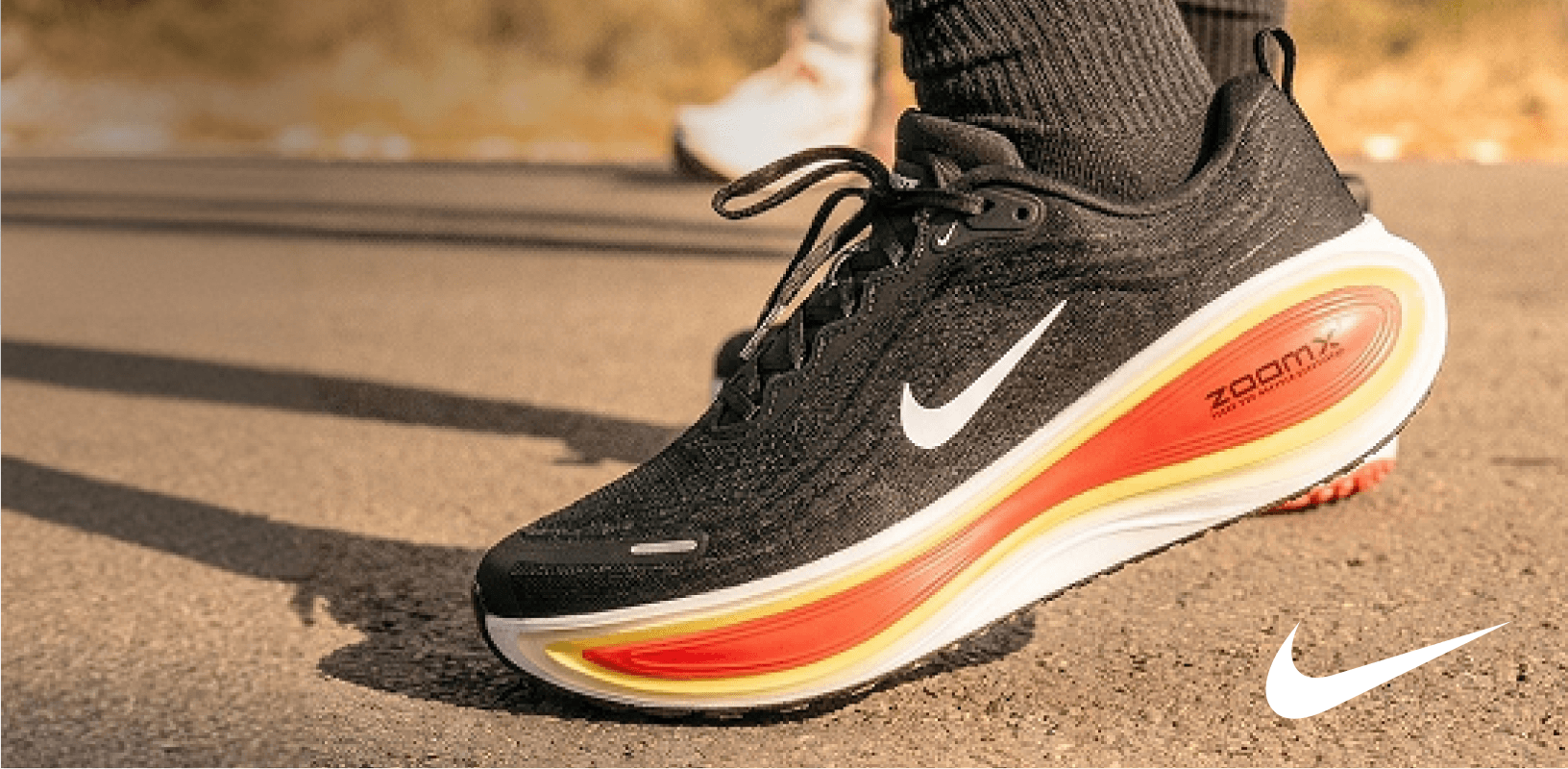 Close-up of a black Nike running shoe on pavement.