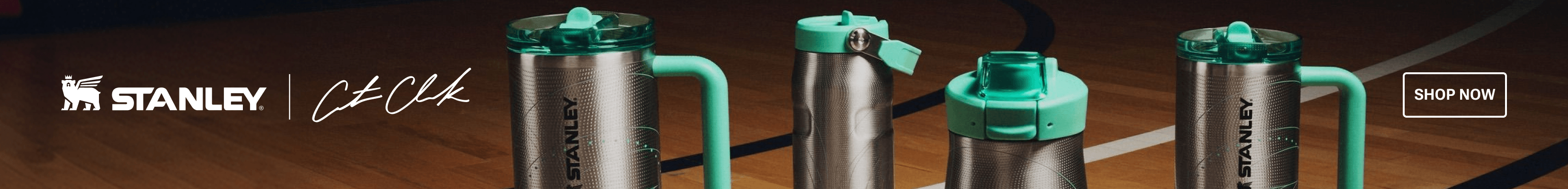 Stanley drinkware collection displayed on a hardwood basketball court, featuring a large handled tumbler, a slim bottle, and a water bottle in stainless steel with mint green accents. White overlay logo for Stanley x Caitlin Clark.