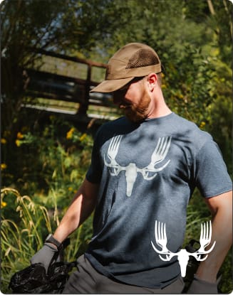 Person outdoors wearing a MeatEater graphic T-shirt. Text promotes featured apparel as seen on MeatEater.