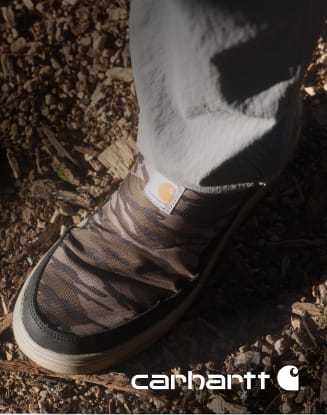 Close-up of a camo-pattern Carhartt work boot with Carhartt logo.