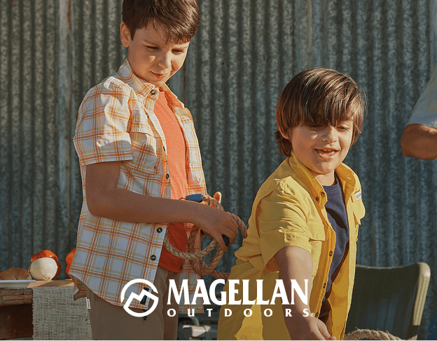 Two people outdoors wearing Magellan Outdoors apparel near a vehicle and building. Magellan Outdoors