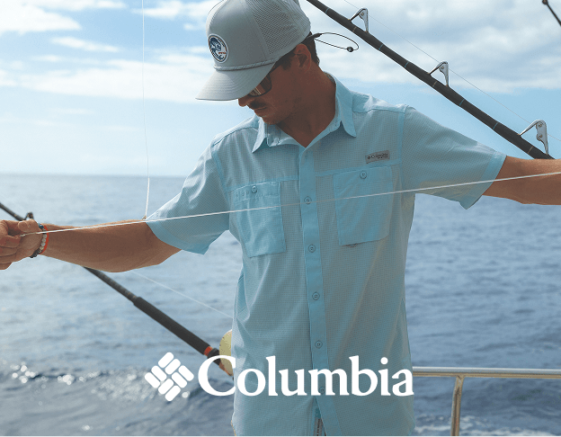 Person fishing from a boat while wearing a Columbia light blue long-sleeve fishing shirt and cap.