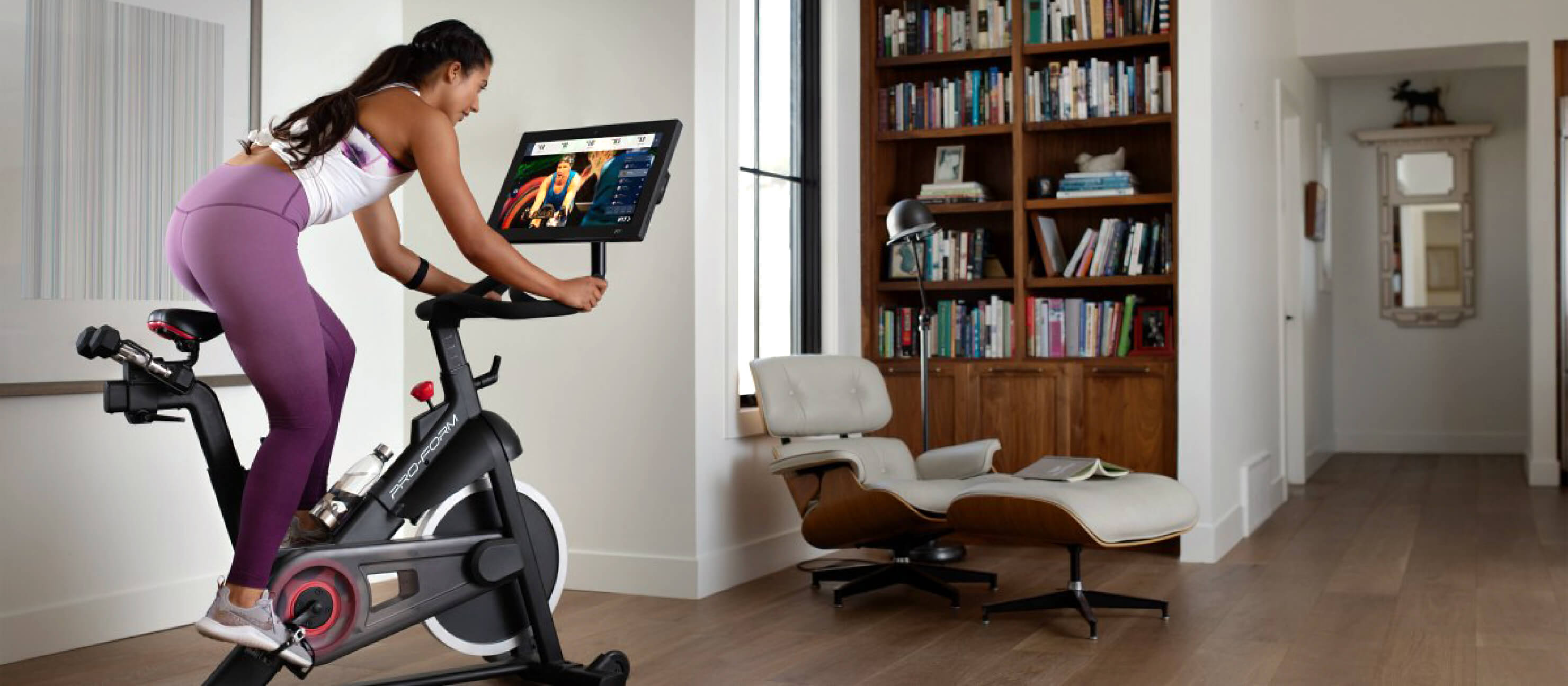 Woman uses the ProForm Pro 22 Studio smart exercise bike in her living room