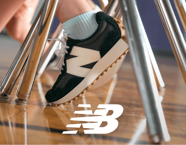 Close-up of New Balance sneakers walking across a wooden floor. New Balance