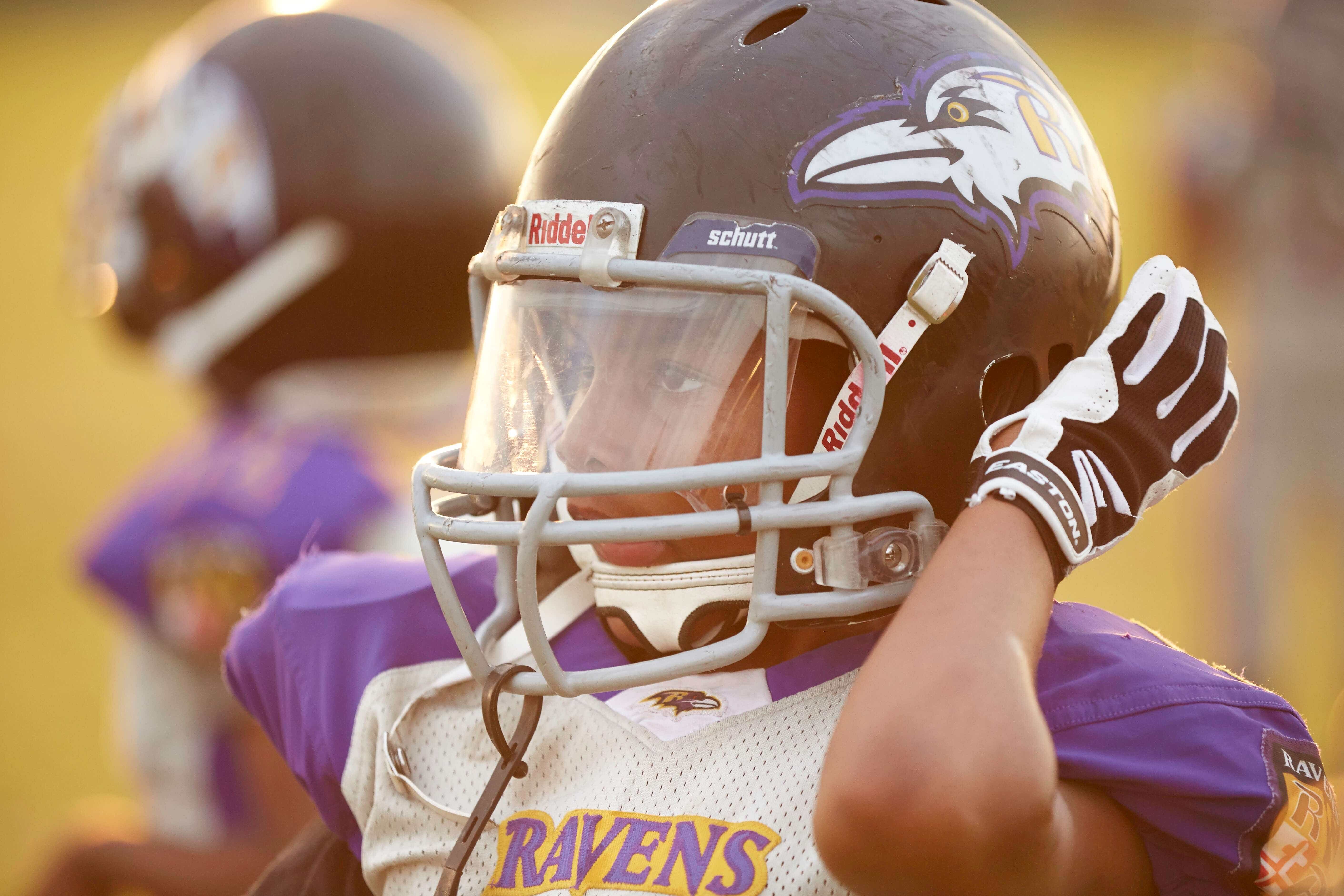 Kid on the football field wearing a helmet