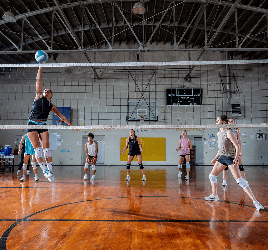 Athletes playing volleyball indoors