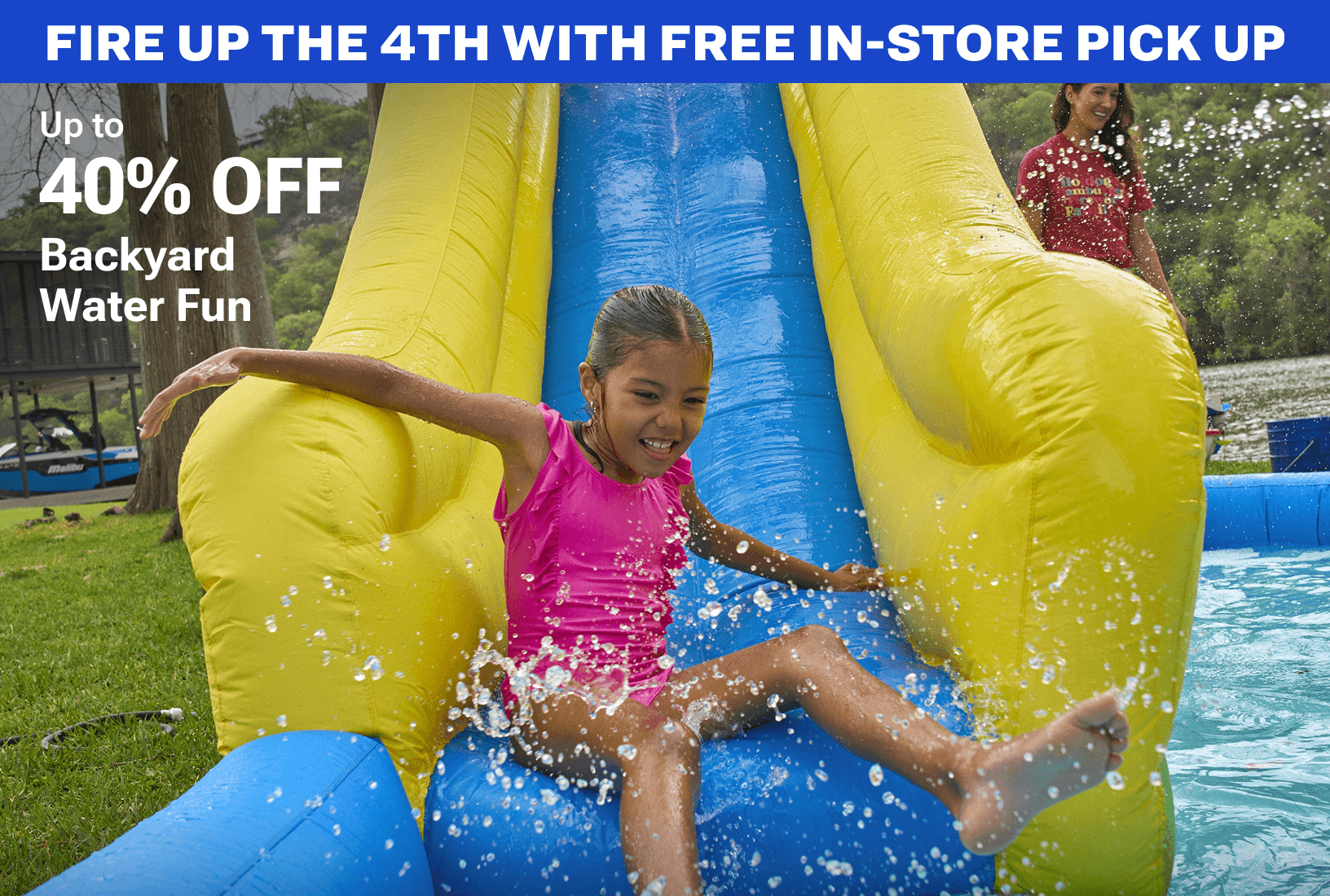 Child sliding down bright yellow inflatable water slide outdoors with water splashing.
