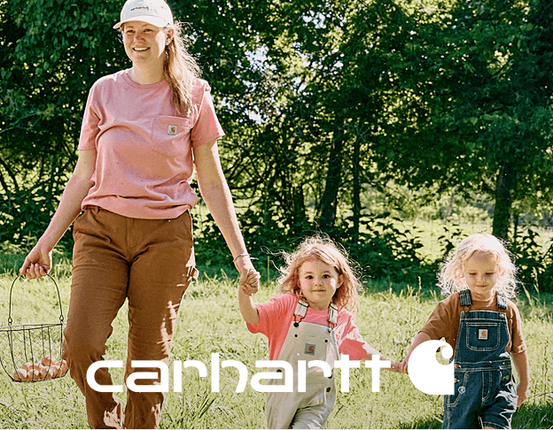 Mother with kids walking outdoors in Carhartt clothing in wooded area.