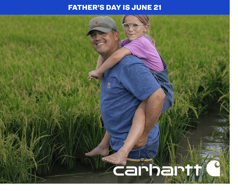 Adult carrying a child in a grassy field while wearing a casual Carhartt K87 t-shirt.