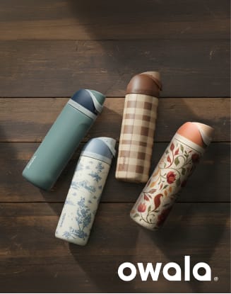 Owala insulated water bottles arranged on a dark wooden surface. Four bottles in teal, white with blue floral pattern, tan plaid, and cream with red botanical design are displayed diagonally, with the Owala logo shown in the lower-right corner.