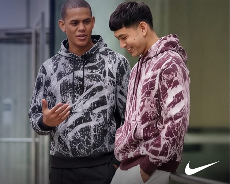 Two people wearing graphic hoodies in black and burgundy colorways.