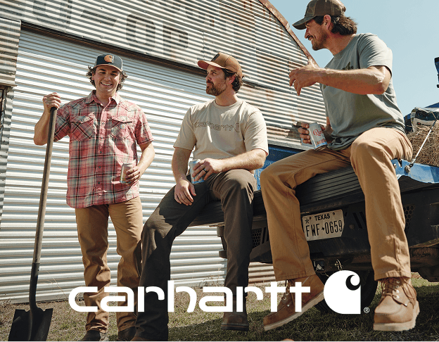 People wearing casual Carhartt workwear seated outside a building with corrugated metal siding.