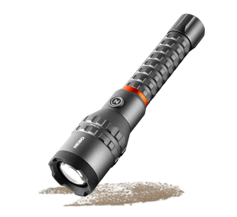 Black handheld flashlight with textured grip and orange accent ring angled on a light gray background.