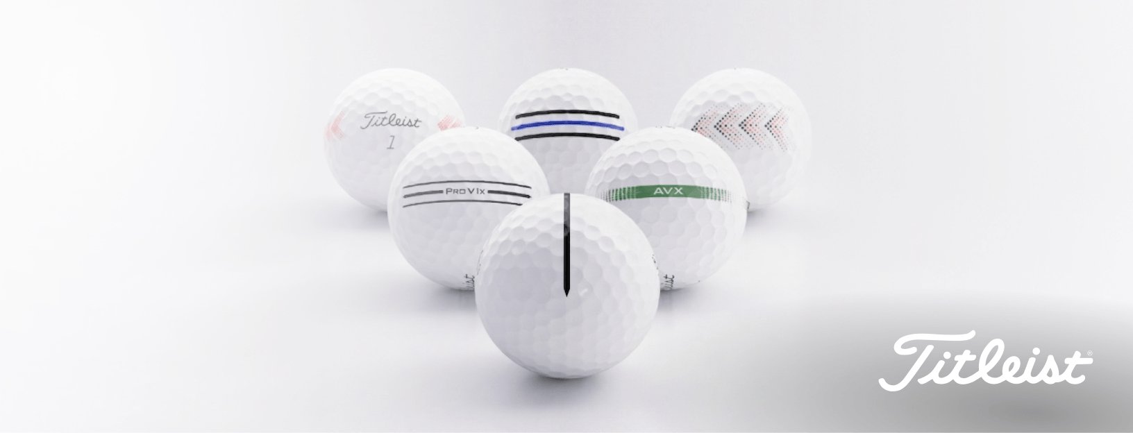 Group of white Titleist 2026 AIM golf balls arranged on a clean studio background, highlighting ball dimples and alignment markings.