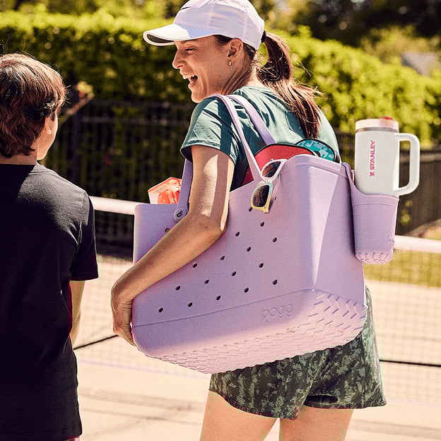 Person holding a large tote bag outdoors