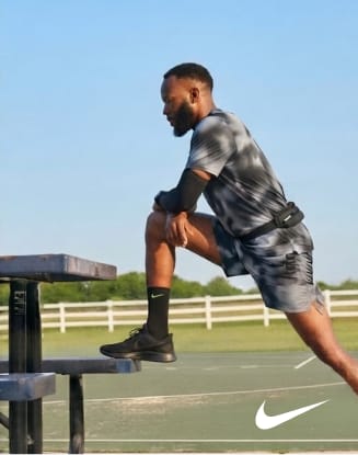 Runner stepping onto an outdoor training platform wearing athletic apparel with Nike logo.