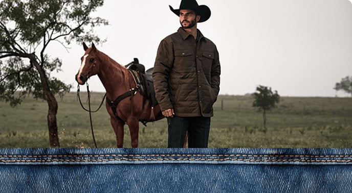 A men wearing Western-style jacket and jeans standing outdoors