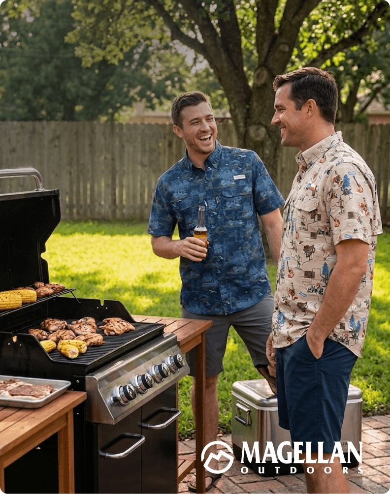 Two people standing outdoors next to a grill, wearing shirts from the Magellan Outdoors State Pride Collection.