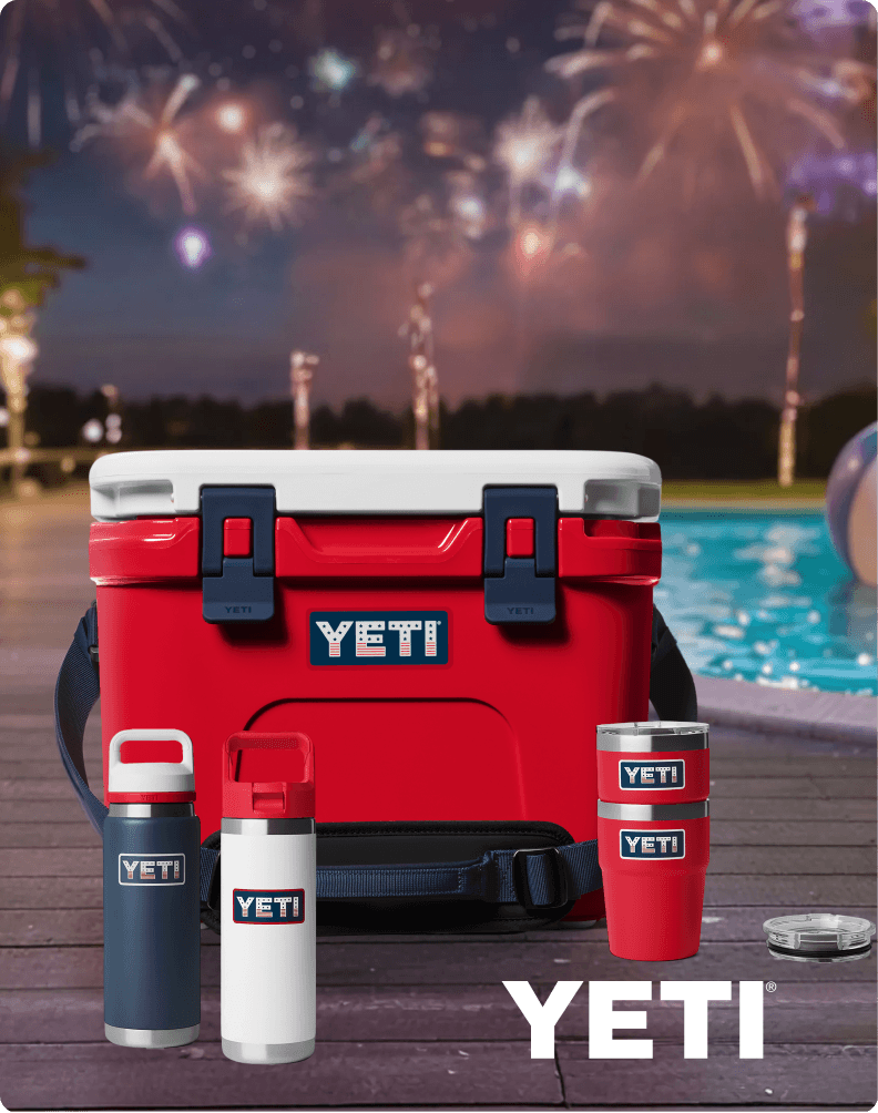 Red YETI hard cooler mounted on the back of a vehicle driving on a dirt road, with YETI branding.