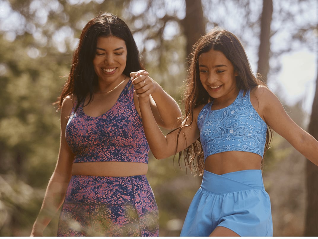 Family walking together outdoors on a warm day, wearing casual spring outfits from Freely.