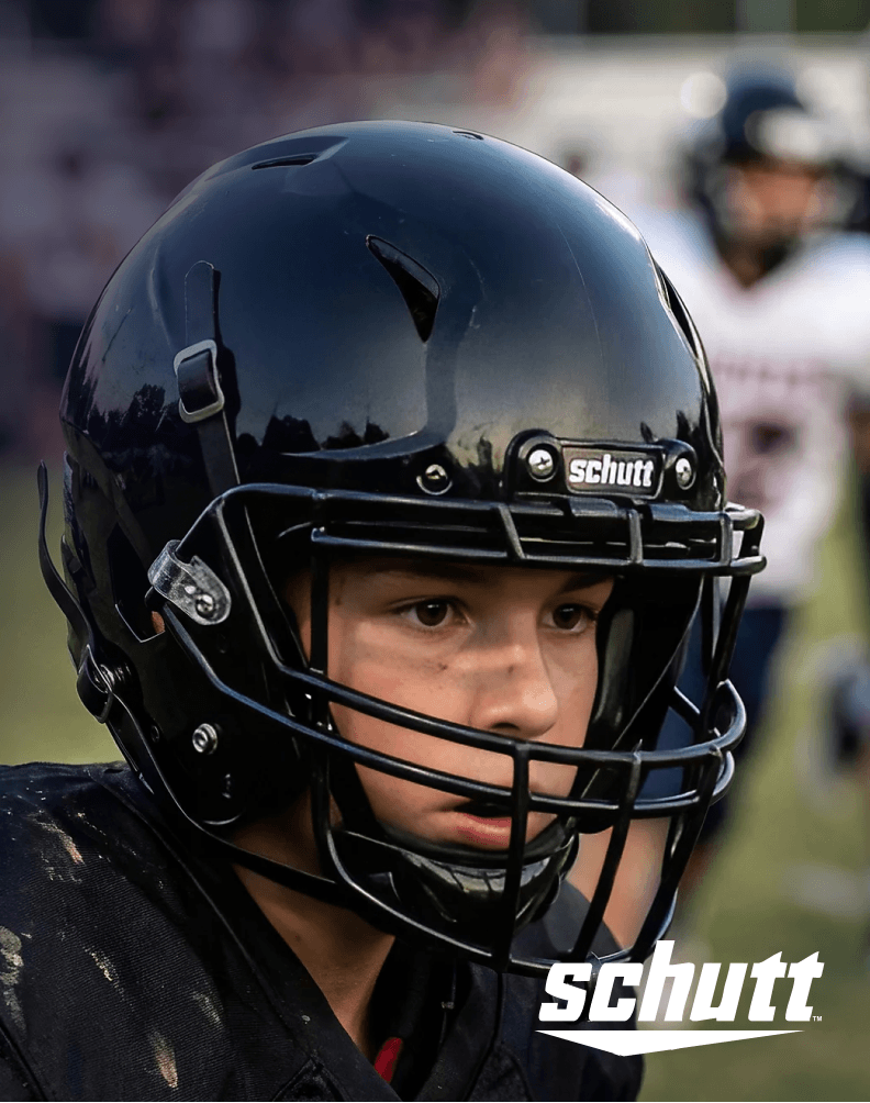 Close-up of a football player wearing a black football helmet during practice on a field.