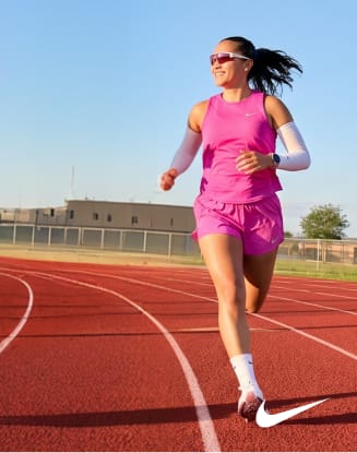 Runner on a track wearing athletic apparel with Nike logo.