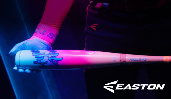 Easton Hype Fire baseball bat illuminated by colorful blue and pink lighting and held by a person wearing batting gloves.