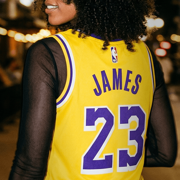 Back view of a yellow NBA basketball jersey with purple trim showing the name JAMES and the number 23.