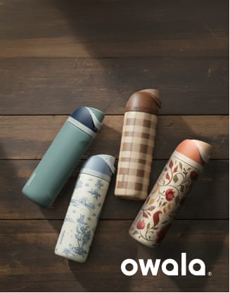 Owala insulated water bottles arranged on a dark wooden surface. Four bottles in teal, white with blue floral pattern, tan plaid, and cream with red botanical design are displayed diagonally, with the Owala logo shown in the lower-right corner.