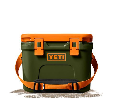 Green and orange YETI soft cooler with orange latches, shoulder strap, and visible YETI logo displayed on a light gray background.